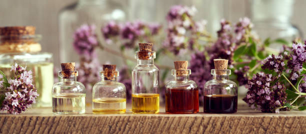Pancarta panorámica de botellas de aceite esencial de aromaterapia con flores frescas de orégano